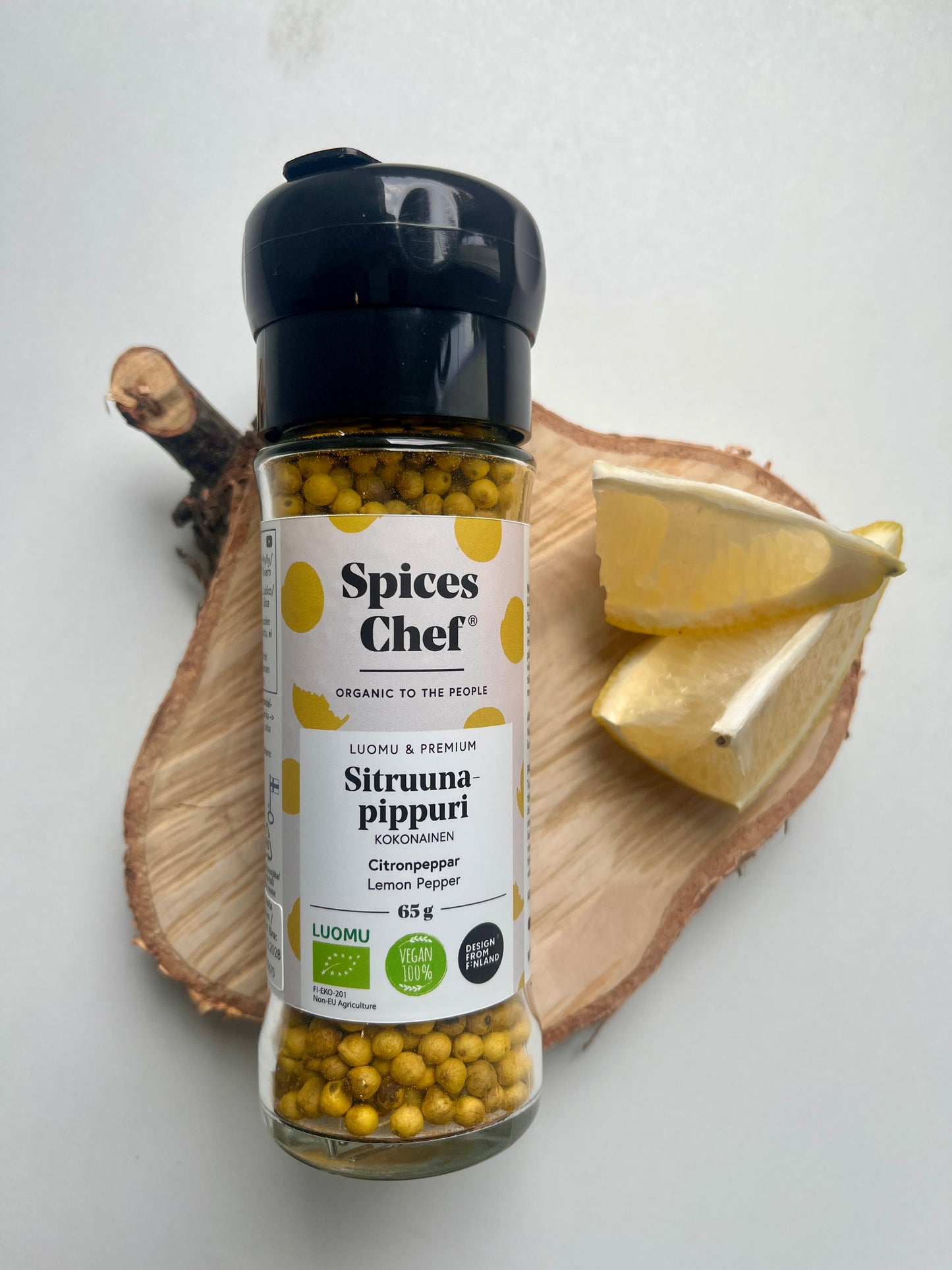 Premium Zitronenpfeffer in Glaskeramik-Mühle Nahaufnahme mit Zitrone